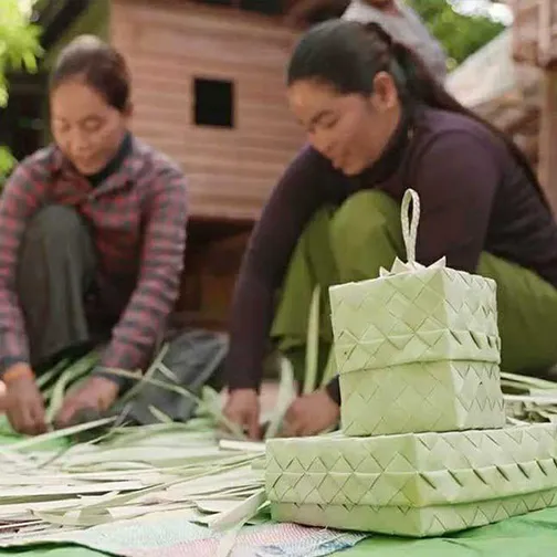 Women weaving SMOK palm-leaf gift boxes